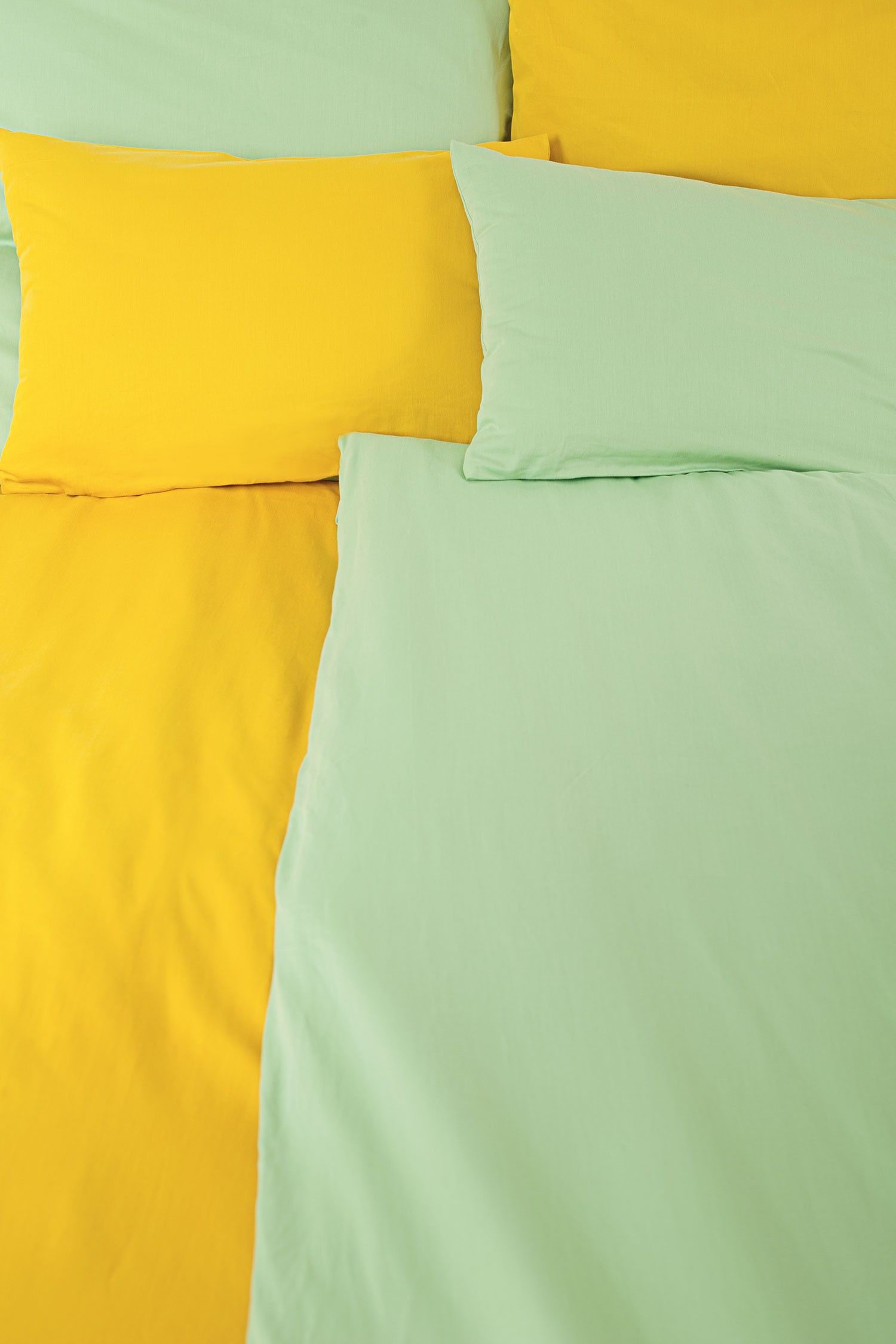 gelbe und schilfgrüne Satinbettwäsche aus bio Baumwolle (kbA) mit Bettdecken und Kissen