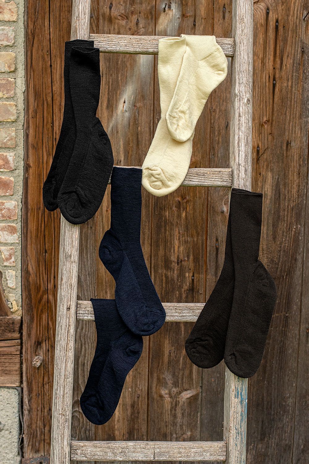 Dünne Wollsocken dünne Finkhof Wollsocken aus bio Wolle (kbT) und Baumwolle (kbA) in allen Farben als Paare über Holzleiter gehängt