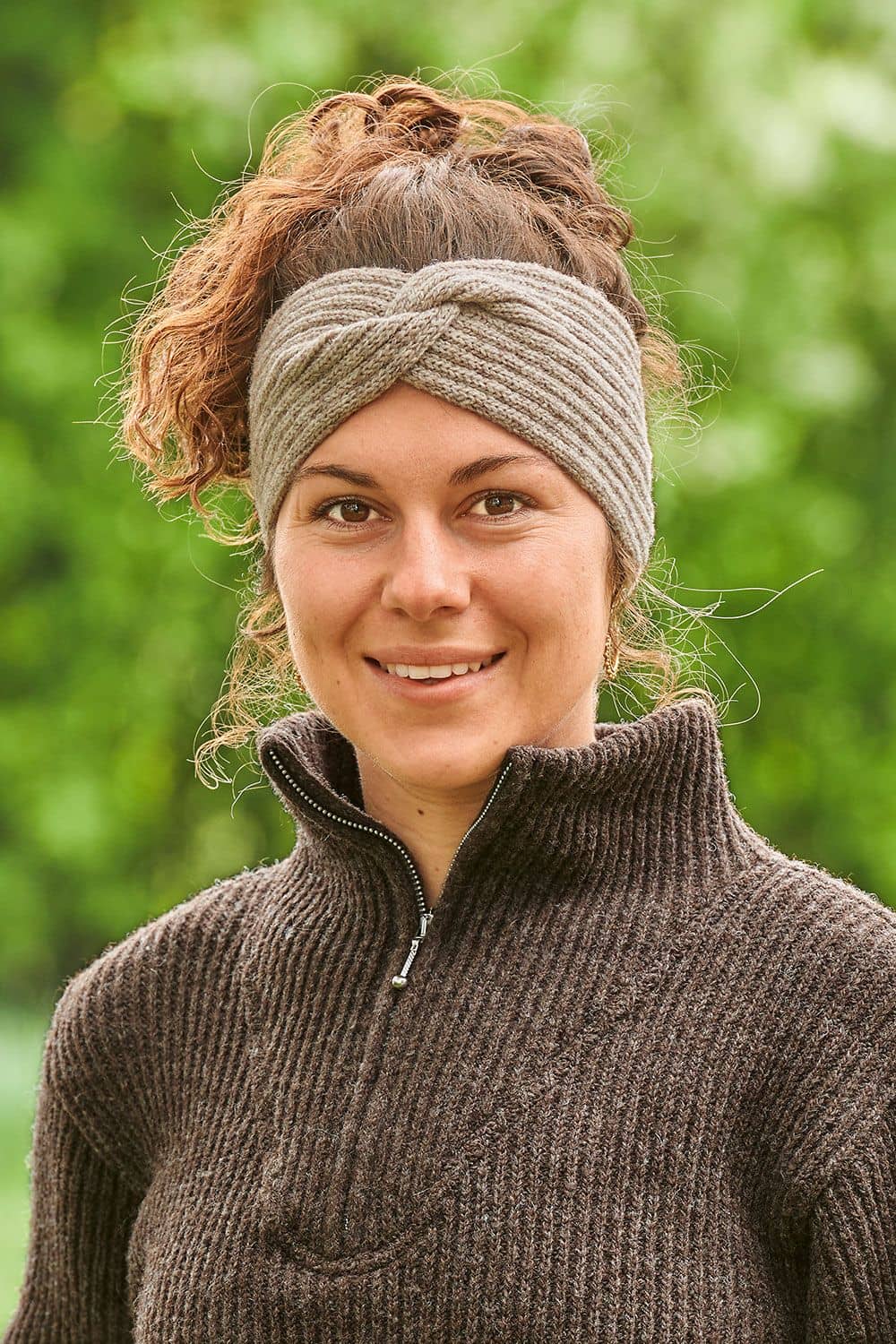 Portraitfoto von Frau mit braunem Zipperpullover, grauem Stirnband mit Twist vom Finkhof aus bio Wolle (kbT) und Dutt