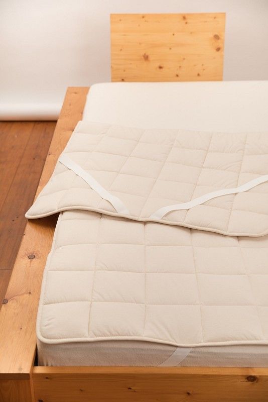 leichtes Wollunterbett auf braunem Holzbett aus bio Wolle (kbT) und bio Baumwolle vom Finkhof mit 180x200cm