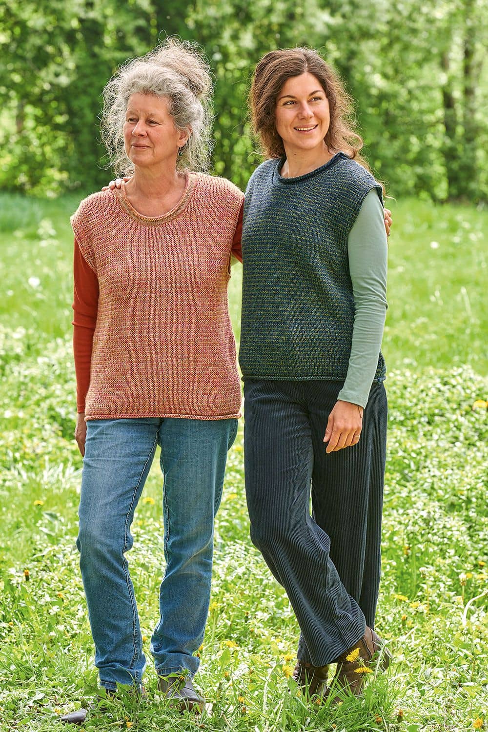Pullunder Melly Frauen auf Wiese tragen grün/blaumelierten und orangen Pullunder aus bio Wolle (kbT) mit unifarbigen Shirts
