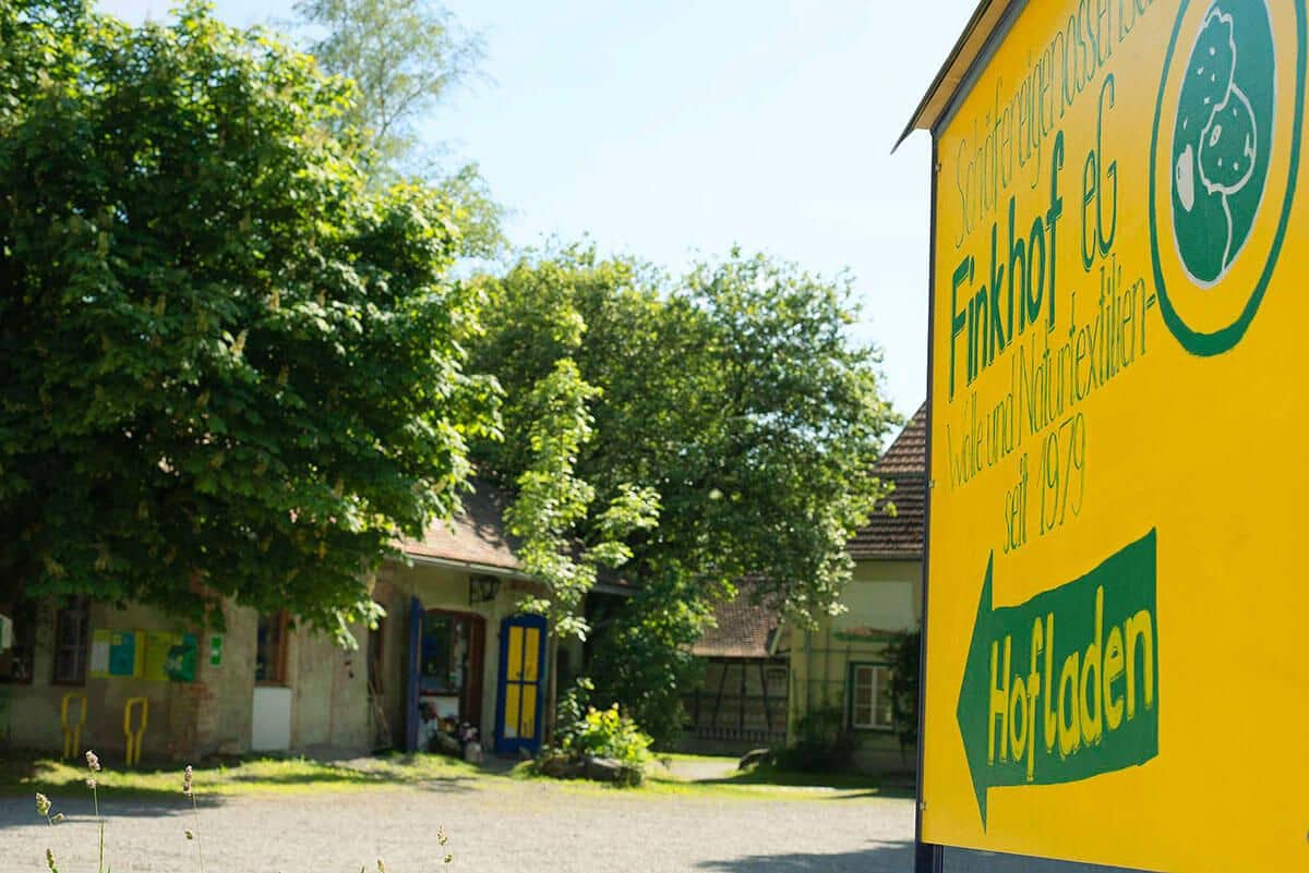 finkhof-hofladen-aussenansicht gelbes Schil, dass auf Finkhof Hofladen zeigt
