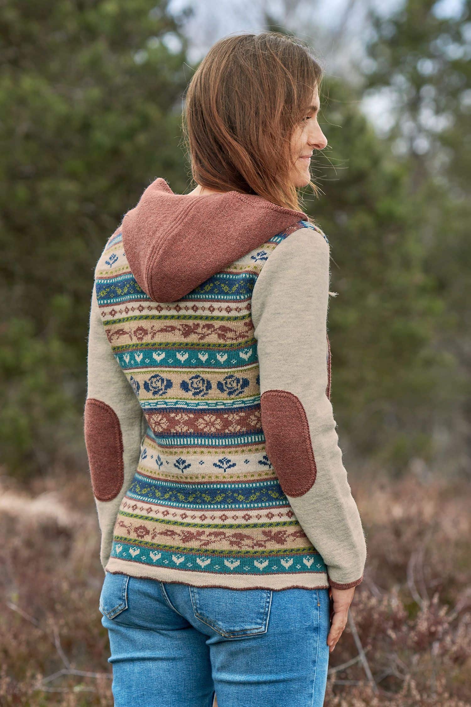 Rückansicht von Frau, die braun gemusterte Jacke mit braunen Ellbogenpatches aus bio Wolle (kbT) trägt