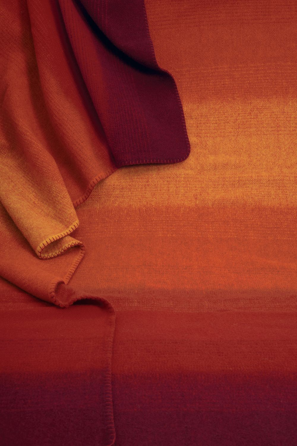 Nahaufnahme Wolldecke in rot und orange mit Farbverlauf aus bio Wolle (kbT)