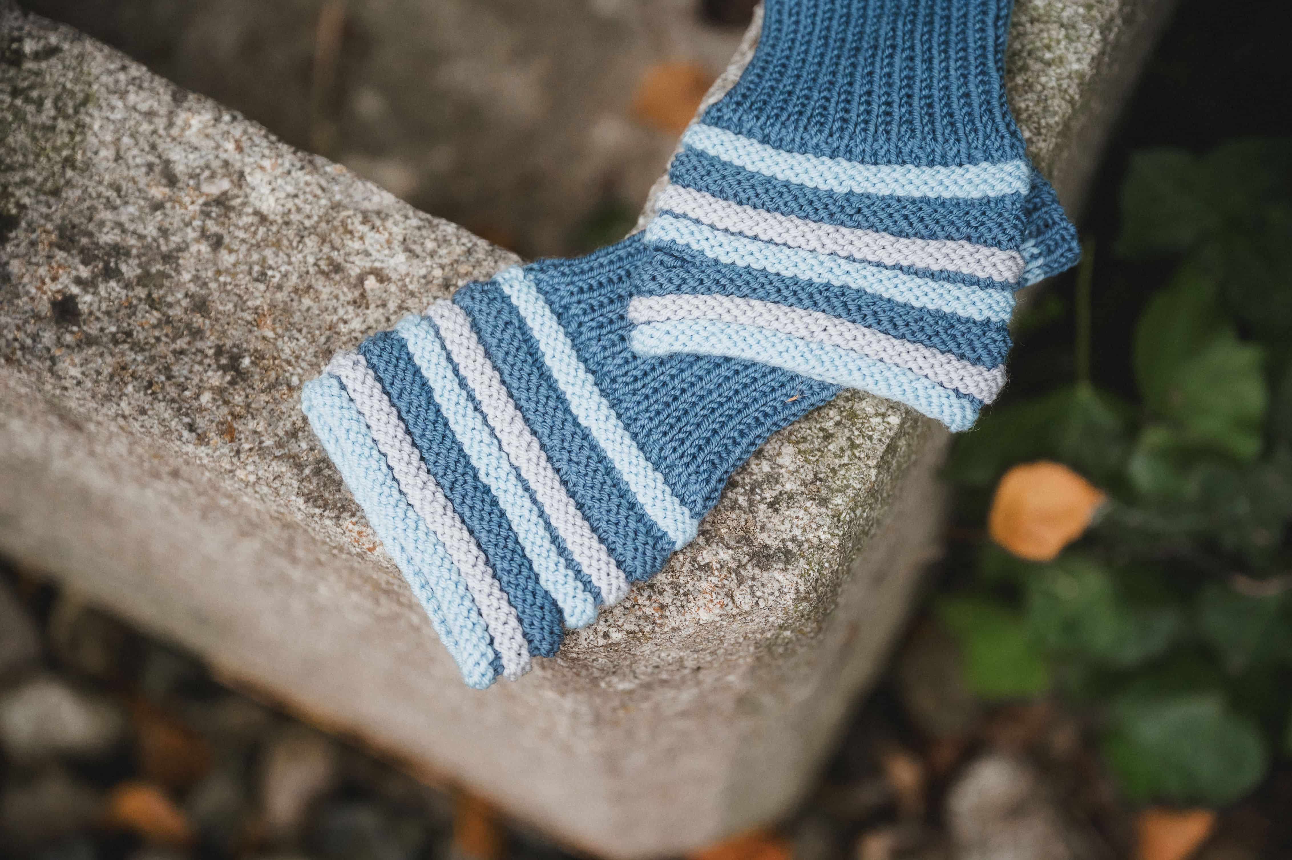 blaue Stulpen liegen auf grauem Stein