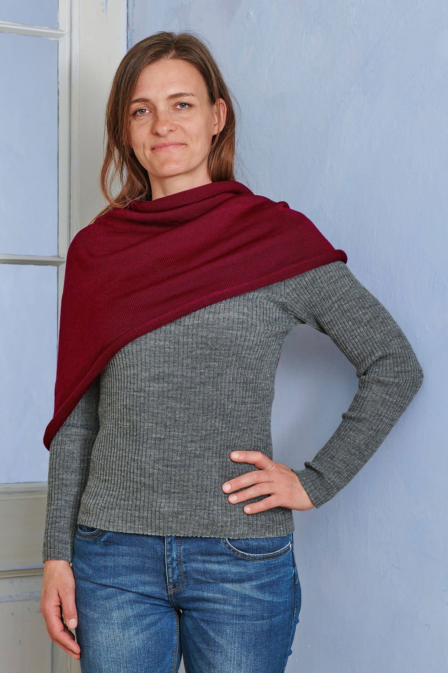 Frau mit grauem Rippshirt hat bordeauxroten Schlauchschal aus bio Wolle (kbT) vom Finkhof um die Schultern