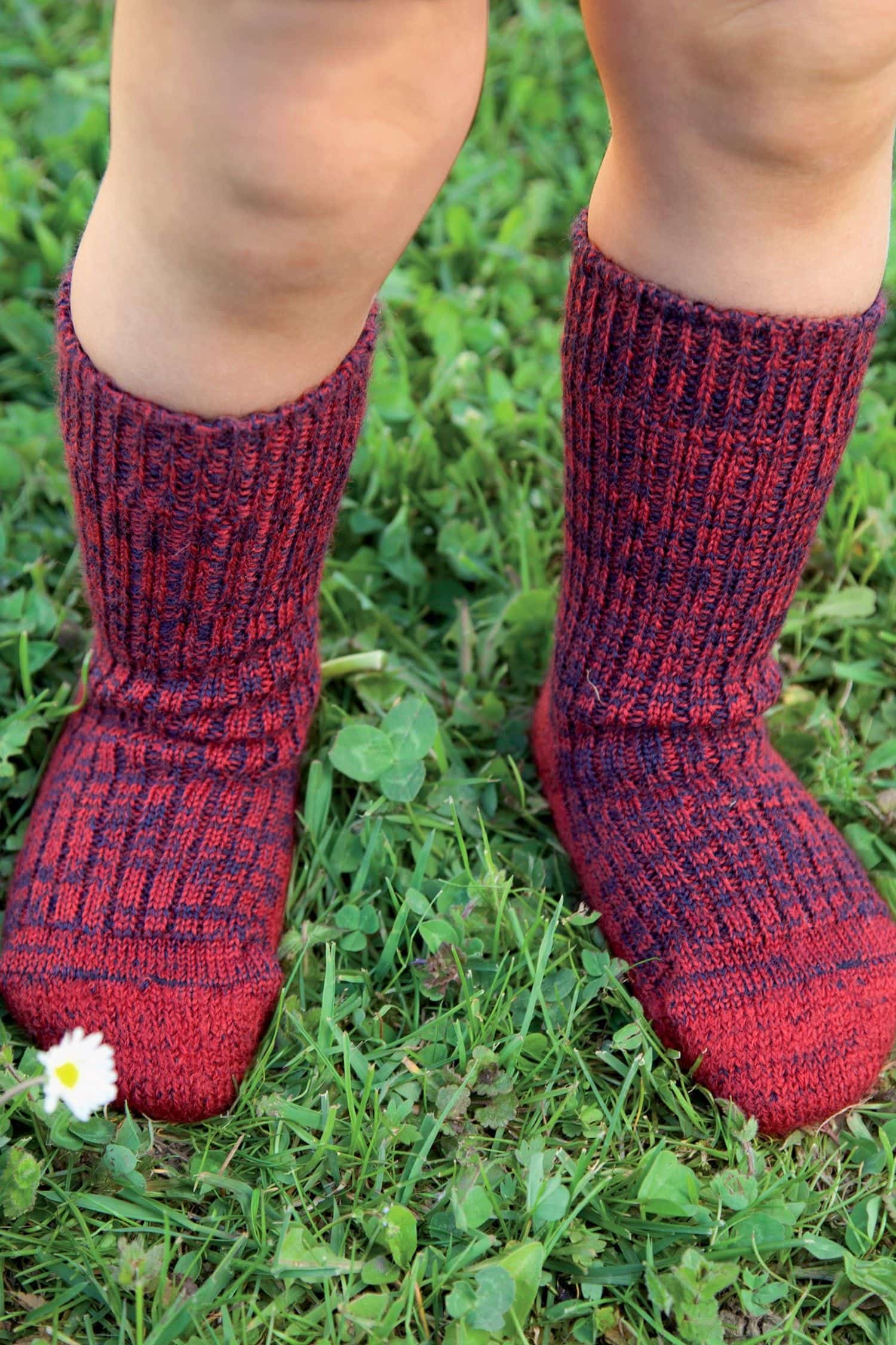 Kind trägt rot/blaue Wollplüschsocken aus bio Wolle (kbT)