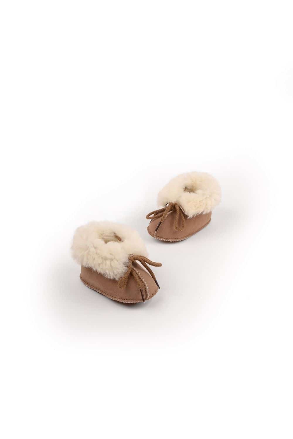 Fellschuh für Kinder aus pflanzlich gegerbtem Leder in braun und weiß von vorne oben auf hellem Hintergrund