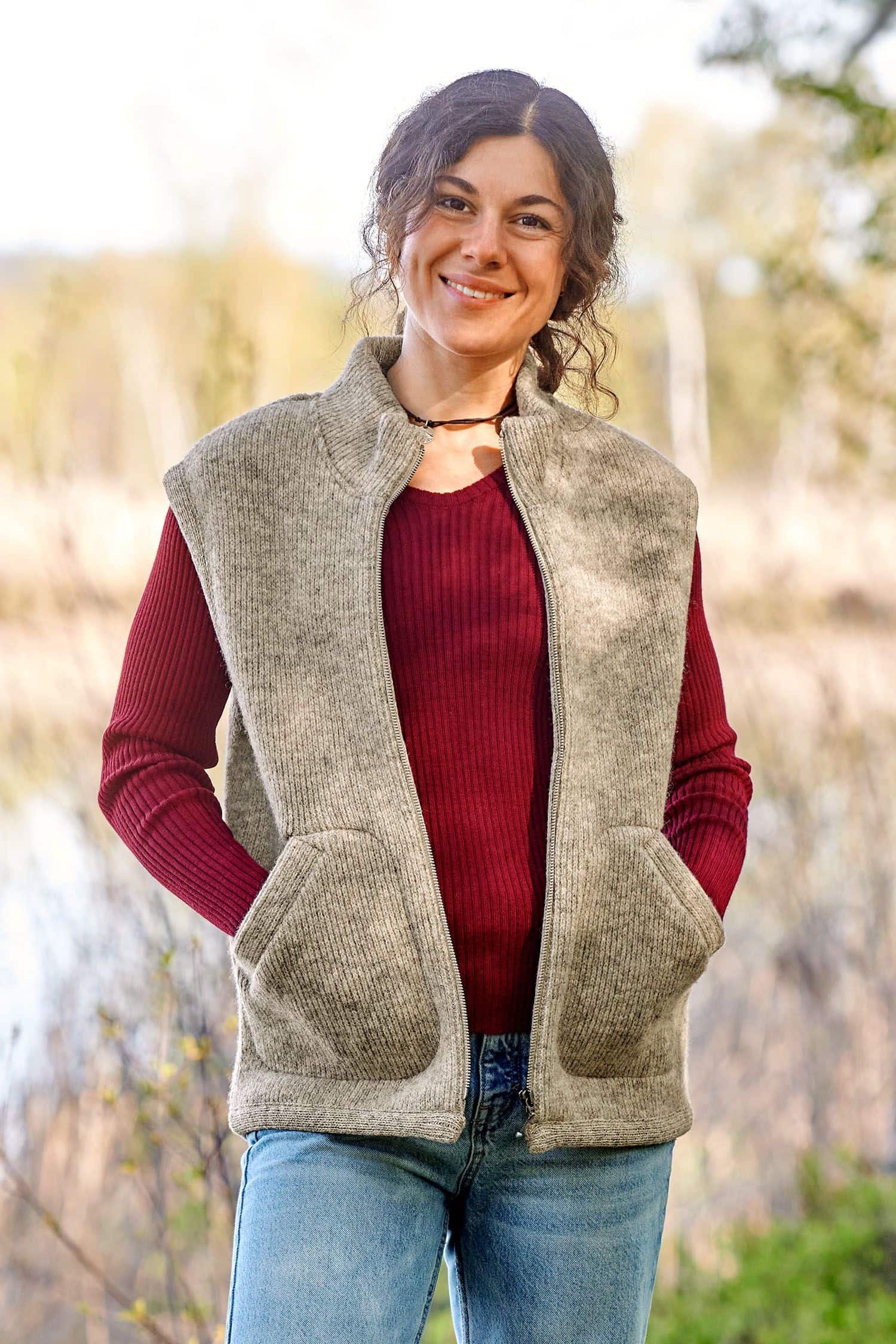 Frau trägt die graue ungefärbte Finkhof Wollwalkweste aus bio Wolle (kbT) ohne Ärmel mit rotem Shirt