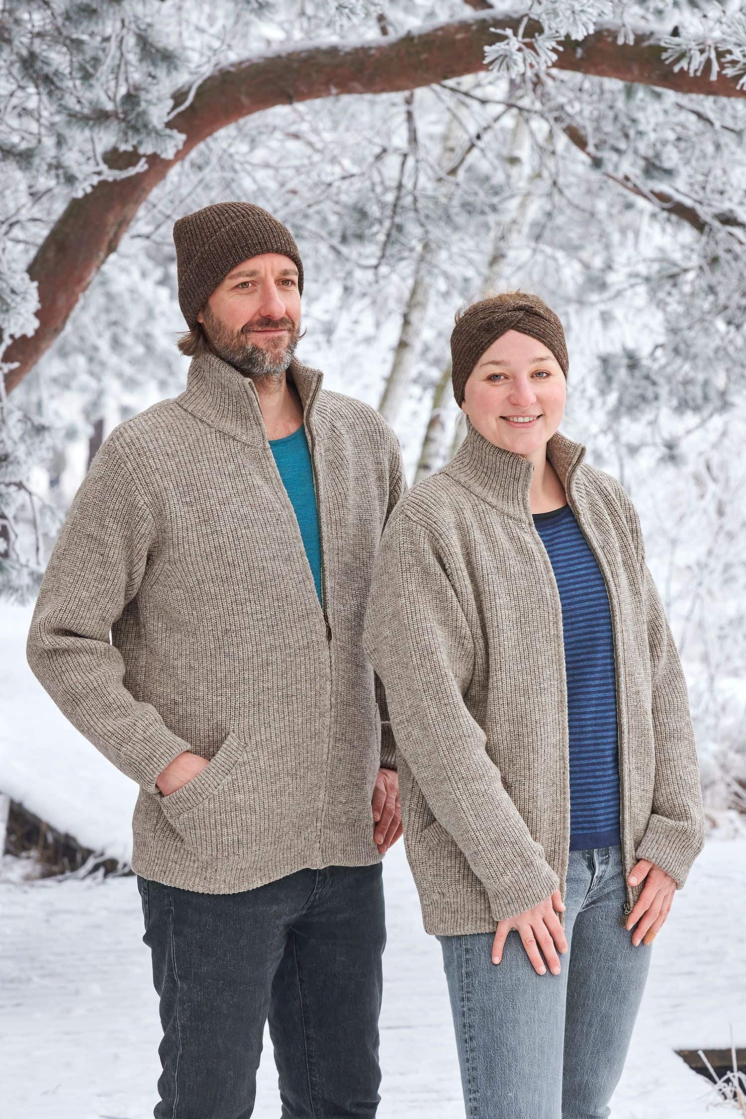 Finkhof-Jacke grau Gr. M Frau und Mann stehen in Schneelandschaft und tragen offene graue Finkhof Jacken aus bio Wolle (kbT) mit blauen Shirts