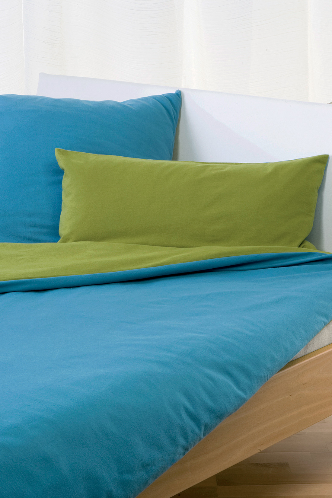 blau grüne Biberwendebettwäsche aus bio Baumwolle (kbA) in weißem Bett