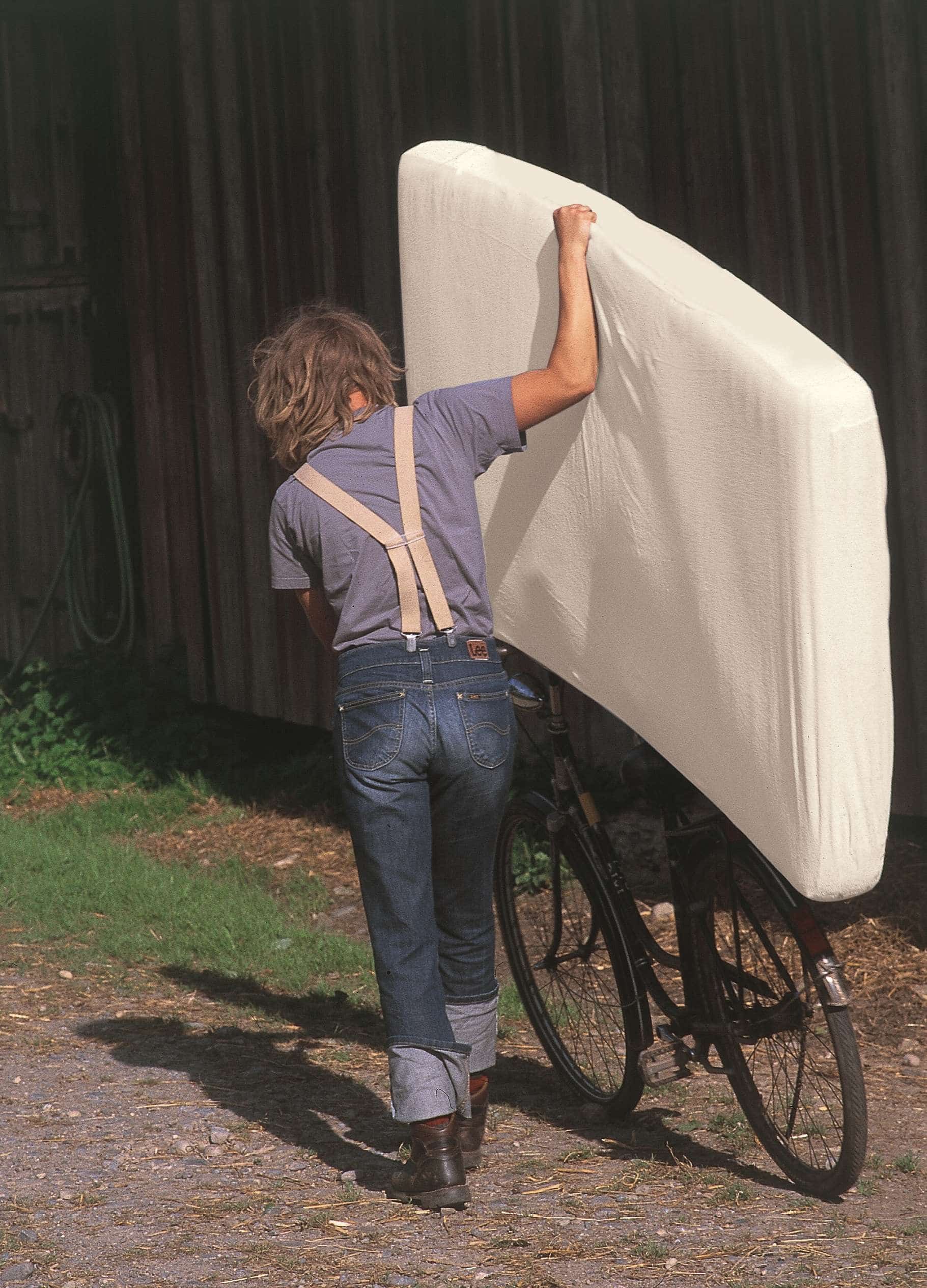 Mann transportiert Finkhof Matratze auf Fahrrad