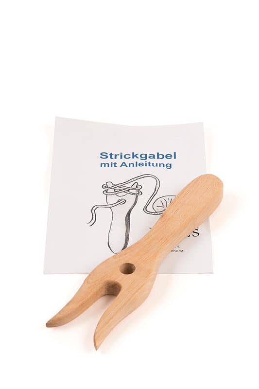Holzstrickgabel liegt auf Anleitung
