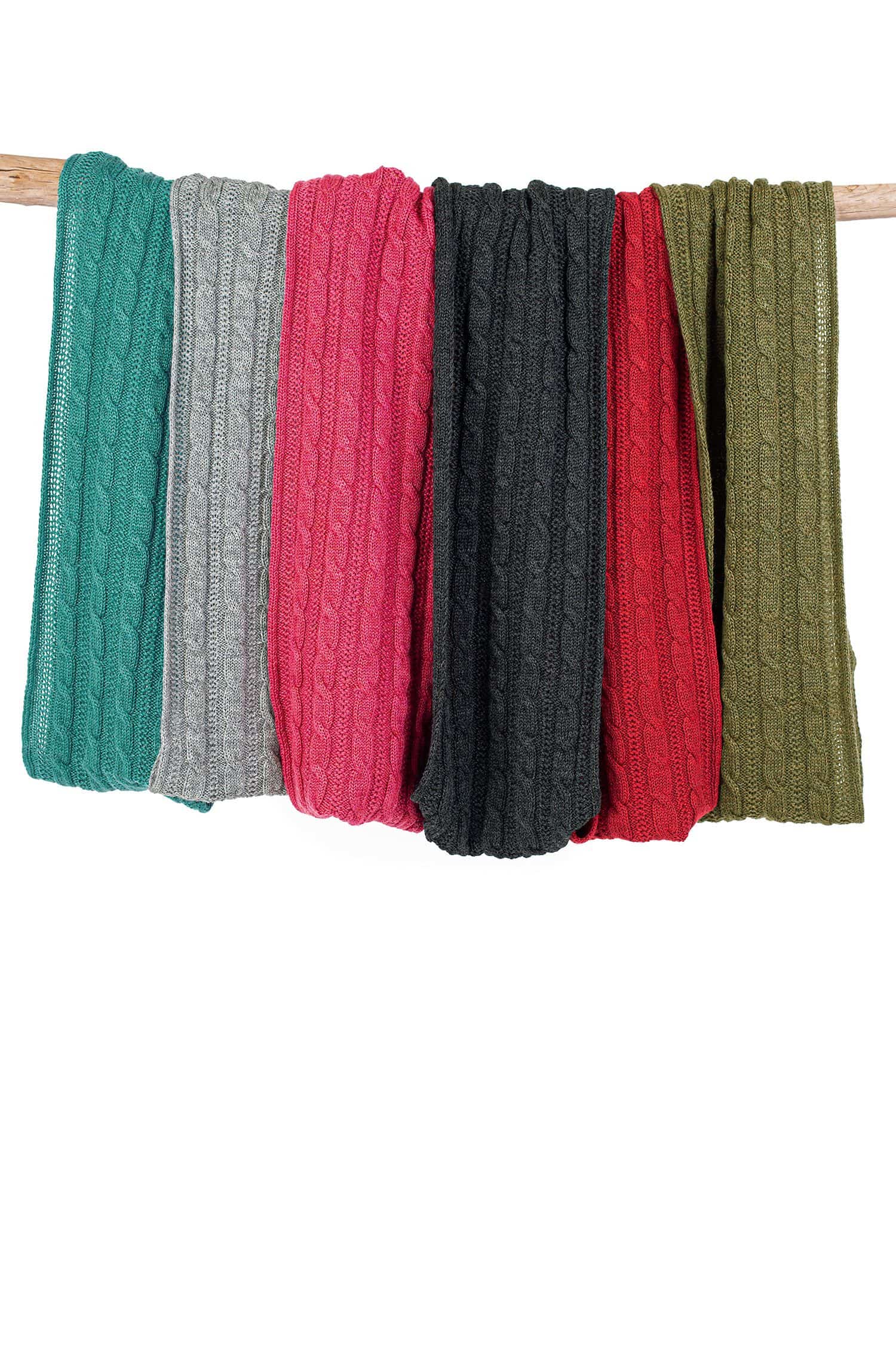 Zopfloop Finkhof Zopfloop in allen sechs Farben aus kbt Schurwolle hängen geordnet auf braunem Ast mit weißem Hintergrund