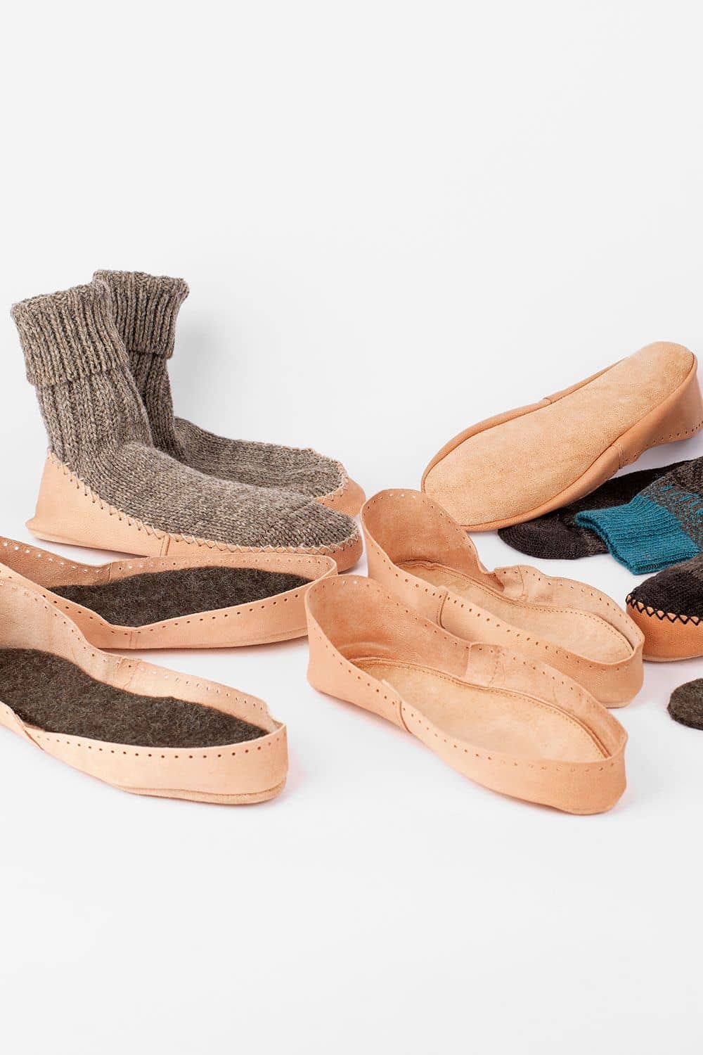 Hüttenschuhsohlen Hüttenschuhsohlen aus pflanzlich gegerbtem Rindsleder auf Bild verteilt, teilweise mit farbigen Hüttenschuhen