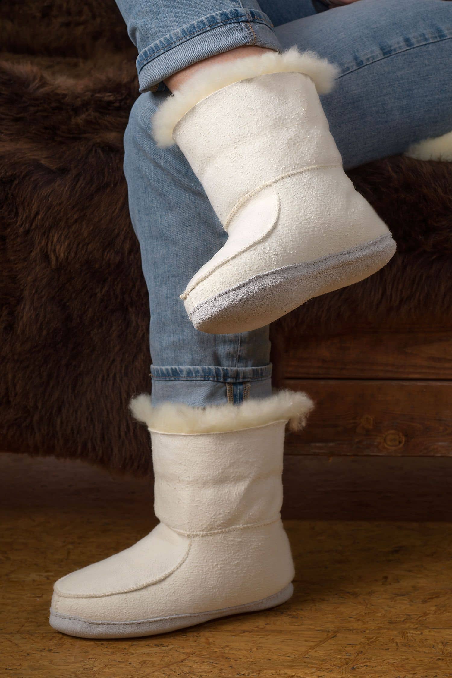 Person trägt relugan gegerbte Fellschuhe aus Schaffell und Rindsleder vom Finbkhof, darunter ein braunes Fell