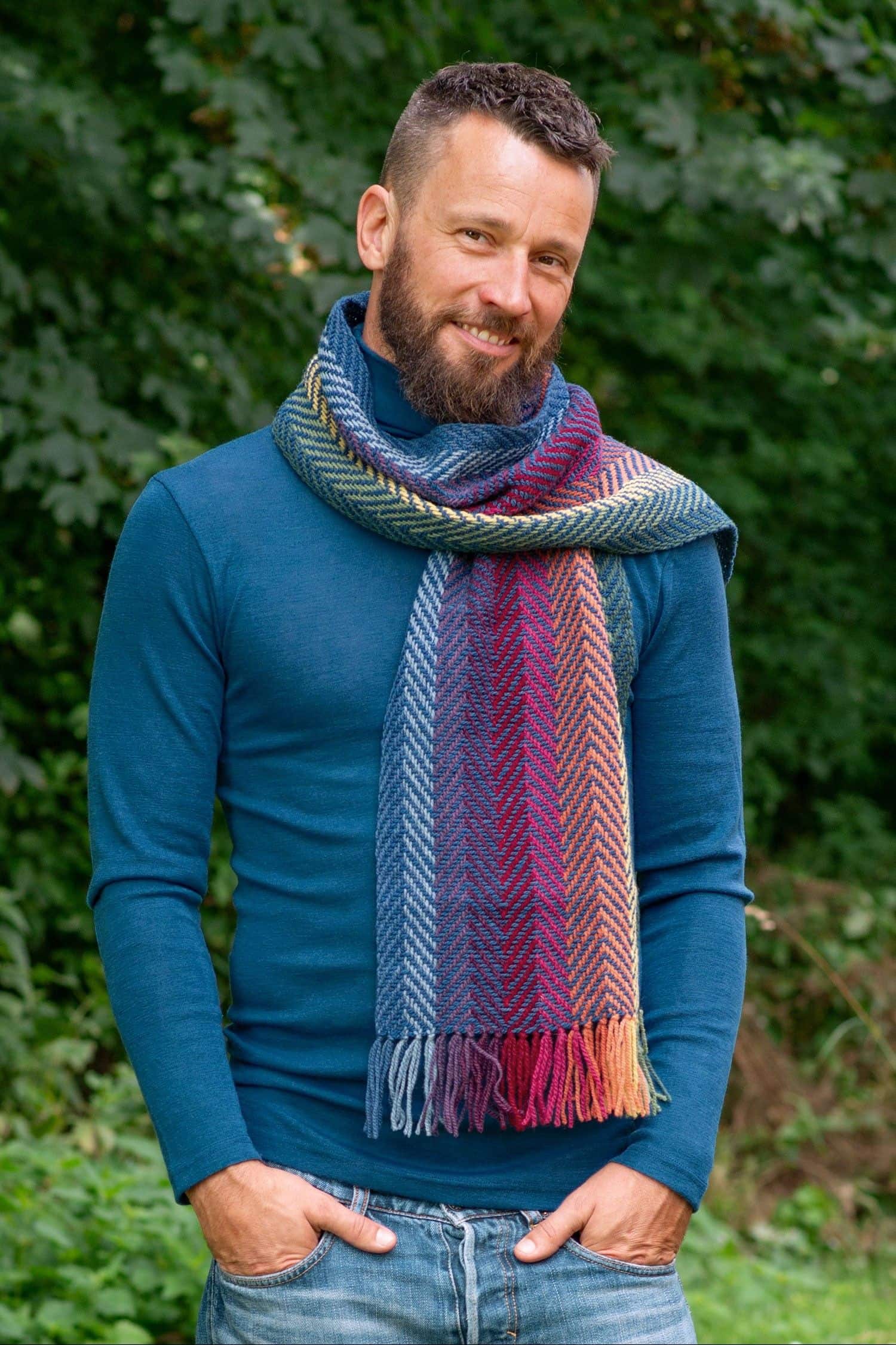 Mann mit blauem Pulli trägt pflanzengefärbten und handgewebten Wollschal aus bio Wolle (kbT) vom Finkhof
