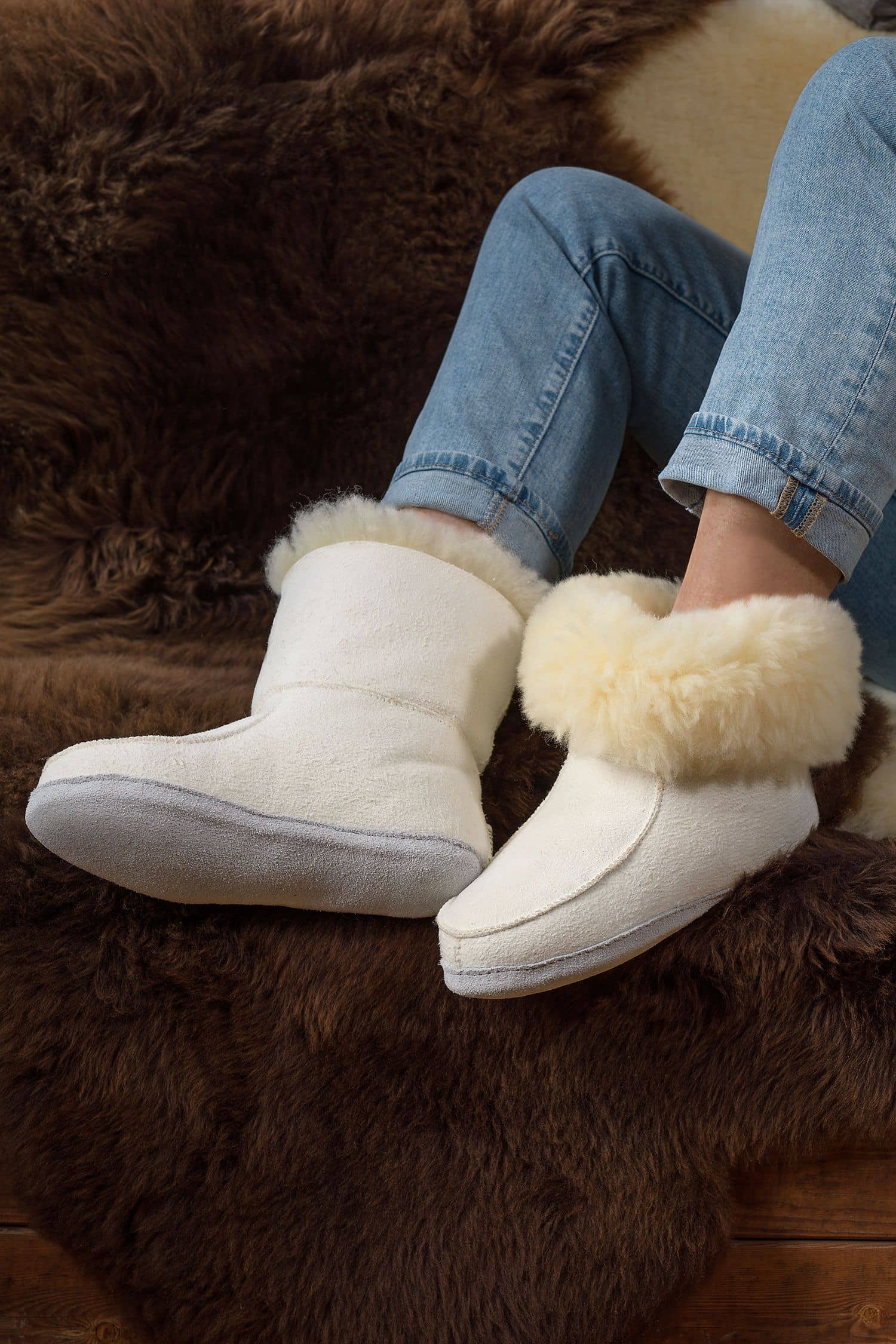 Person trägt relugan gegerbte Fellschuhe aus Schaffell und Rindsleder vom Finbkhof, darunter ein braunes Fell