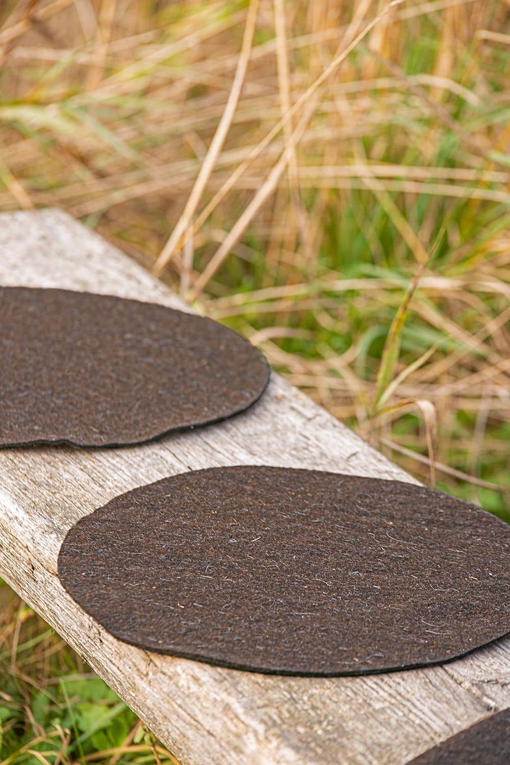 runde braune Sitzunterlagen aus Wollfilz von bio Finkhof Wolle (kbT) auf einer Bank