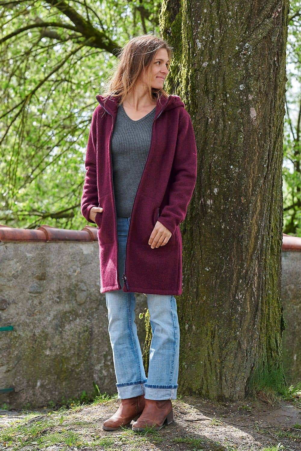 Frau trägt Jeans, graues Rippshirt und einen gewalkten Wollmantel in beere