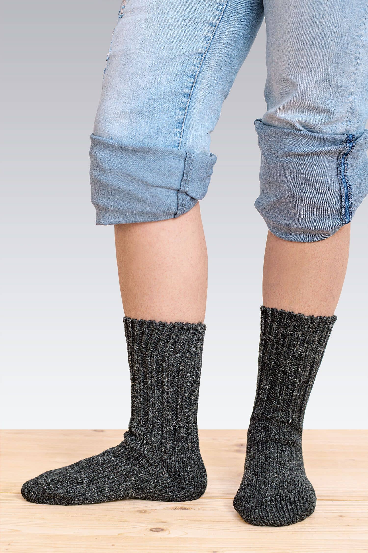 Dicke Finkhof-Socken gefärbt Person mit gekrempelter Jeans trägt dicke anthrazitfarbene Finkhof Socken aus bio Wolle (kbT)