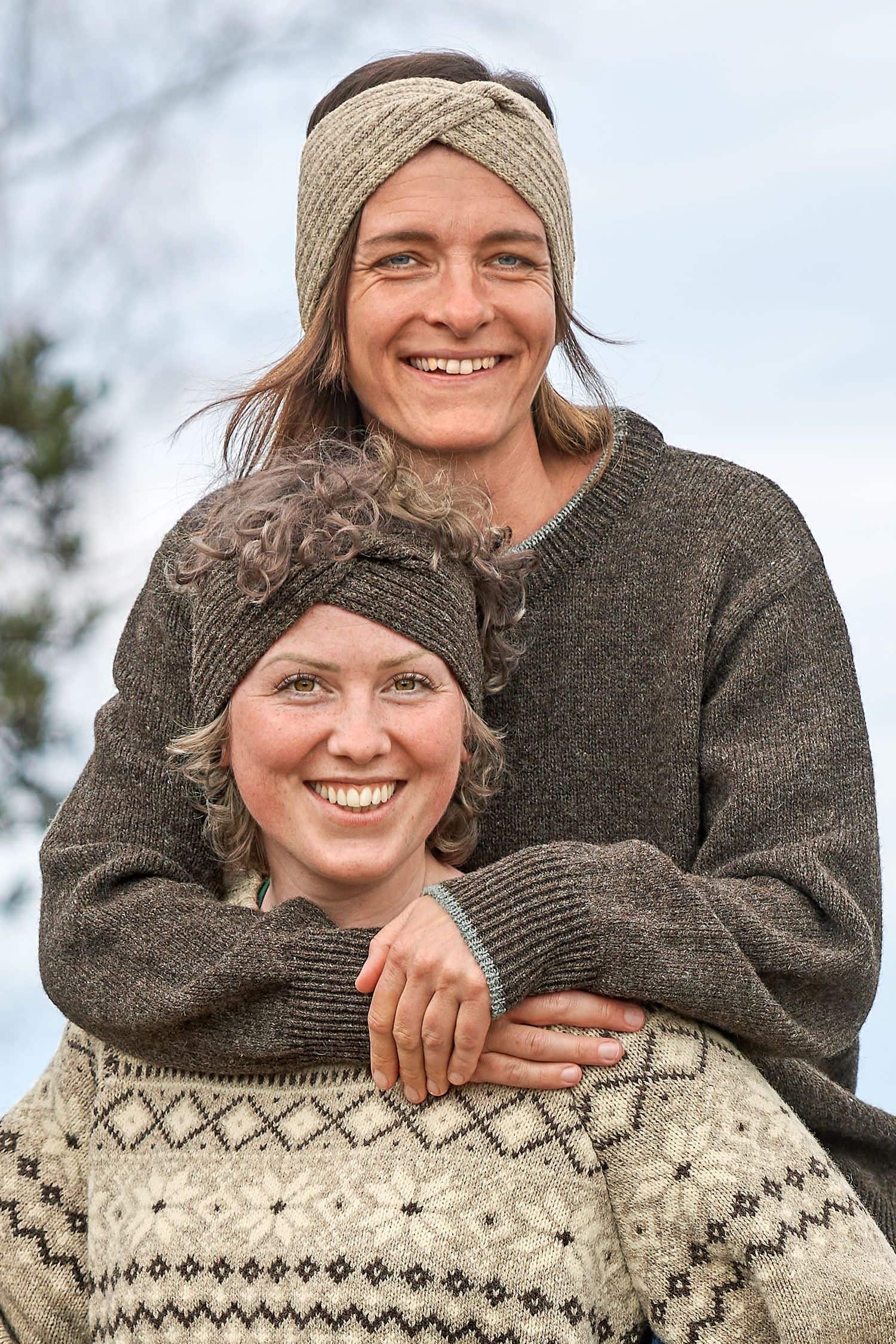 Finkhof-Stirnband Twist Frauen tragen Wollpullis und graues und braunes Stirnband mit Twist vom Finkhof aus bio Wolle (kbT)