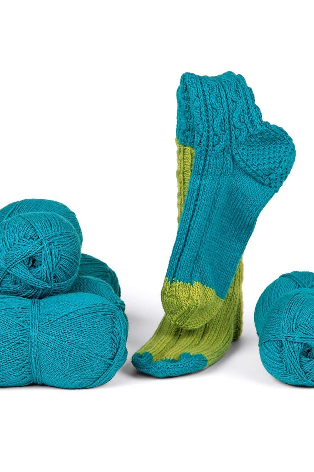 feine Finkhof Sockenwolle in petrol aus bio Wolle (kbT) mit Wollknäulen und fertiger Socke