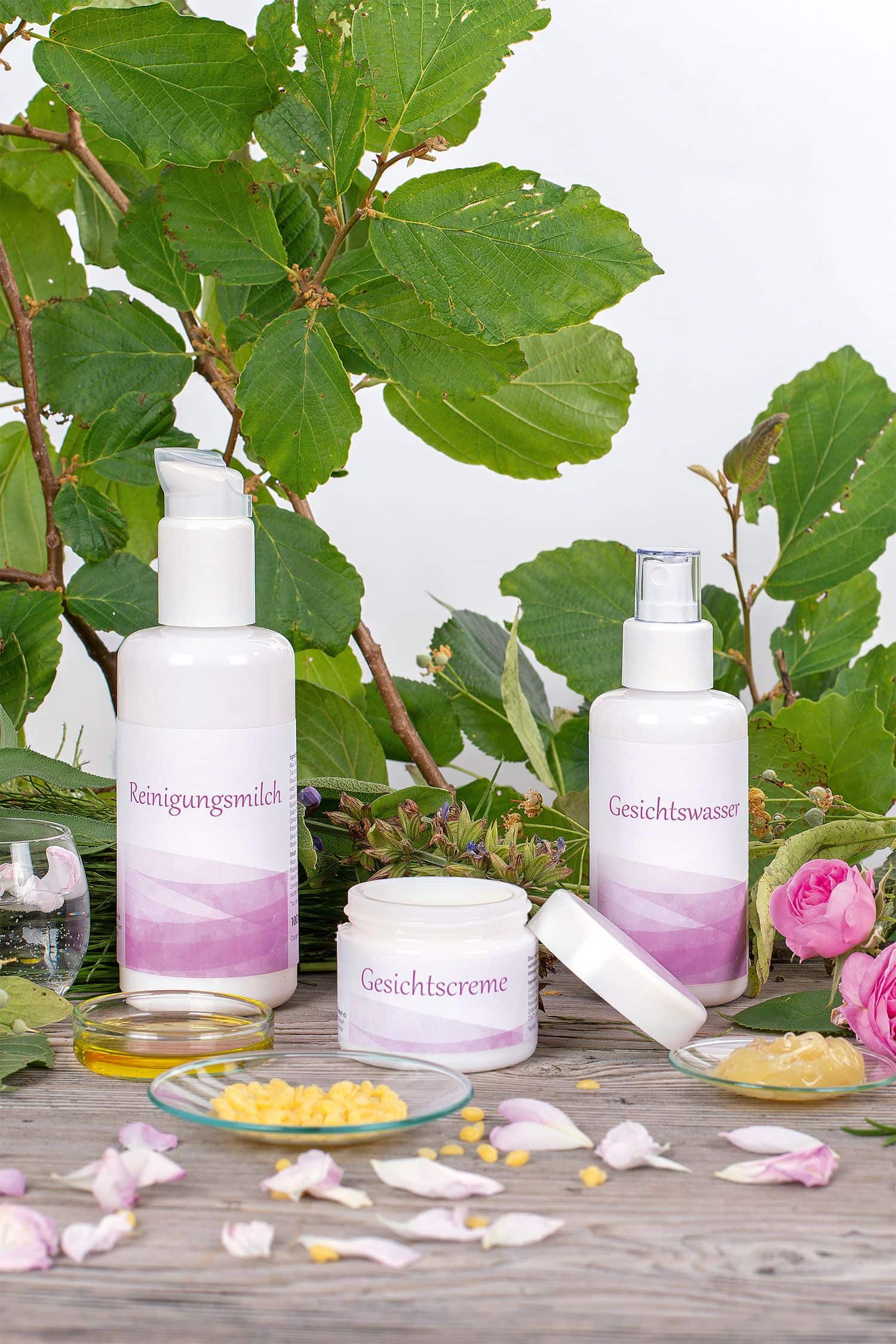 Finkhof Gesichtspflege Set auf Stimmungsbild mit Ölen, Gläschen, Rosen und Ästen