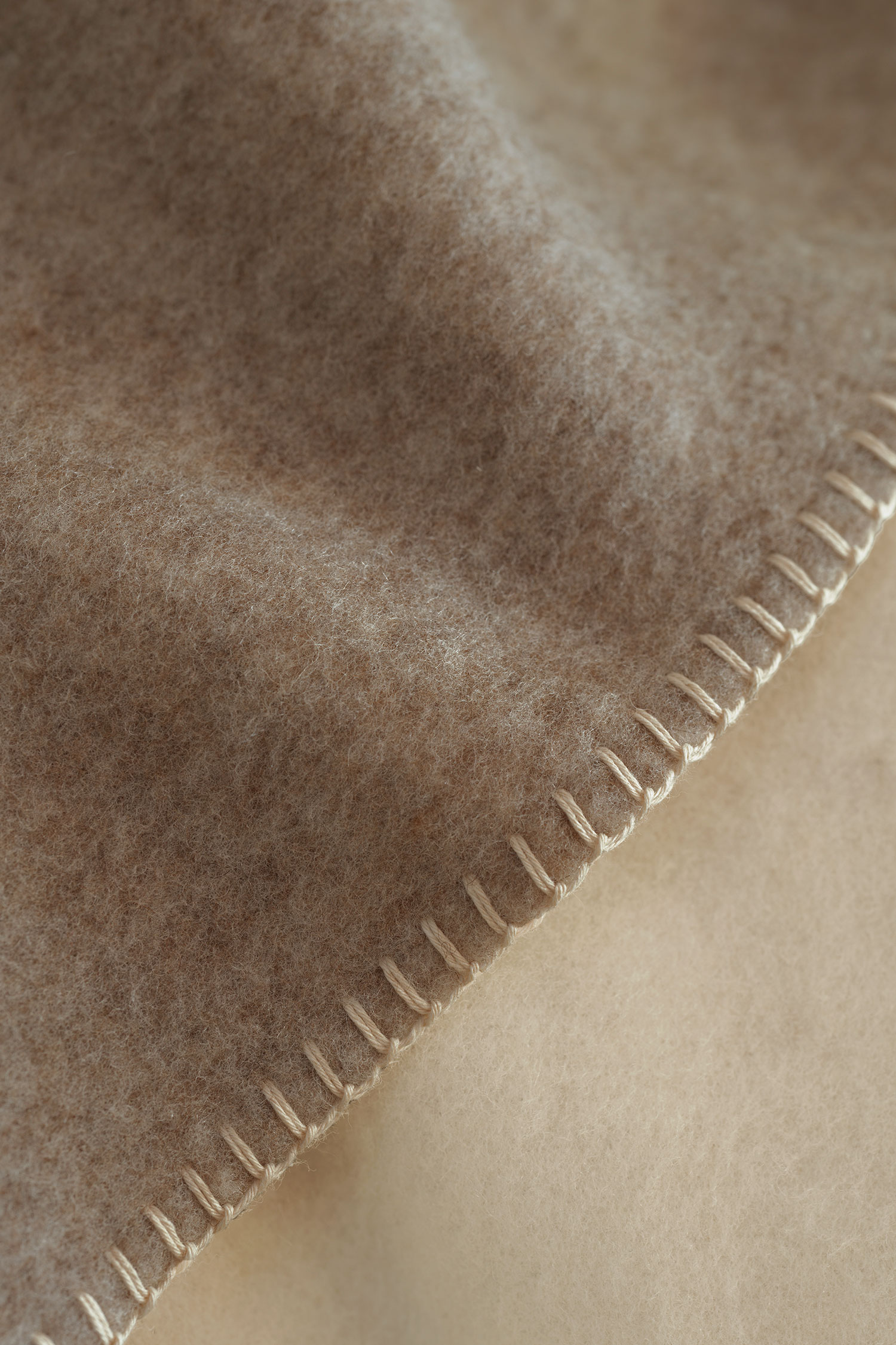 Saum der weiß beigen Wolldecke aus bio Wolle (kbT)
