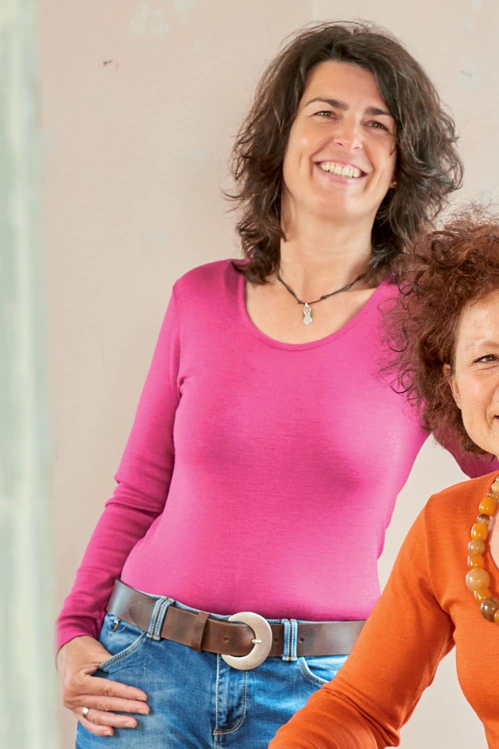 Frau mit Jeans und Gürtel trägt pinkes Langarmshirt aus bio Wolle (kbT) und Seide