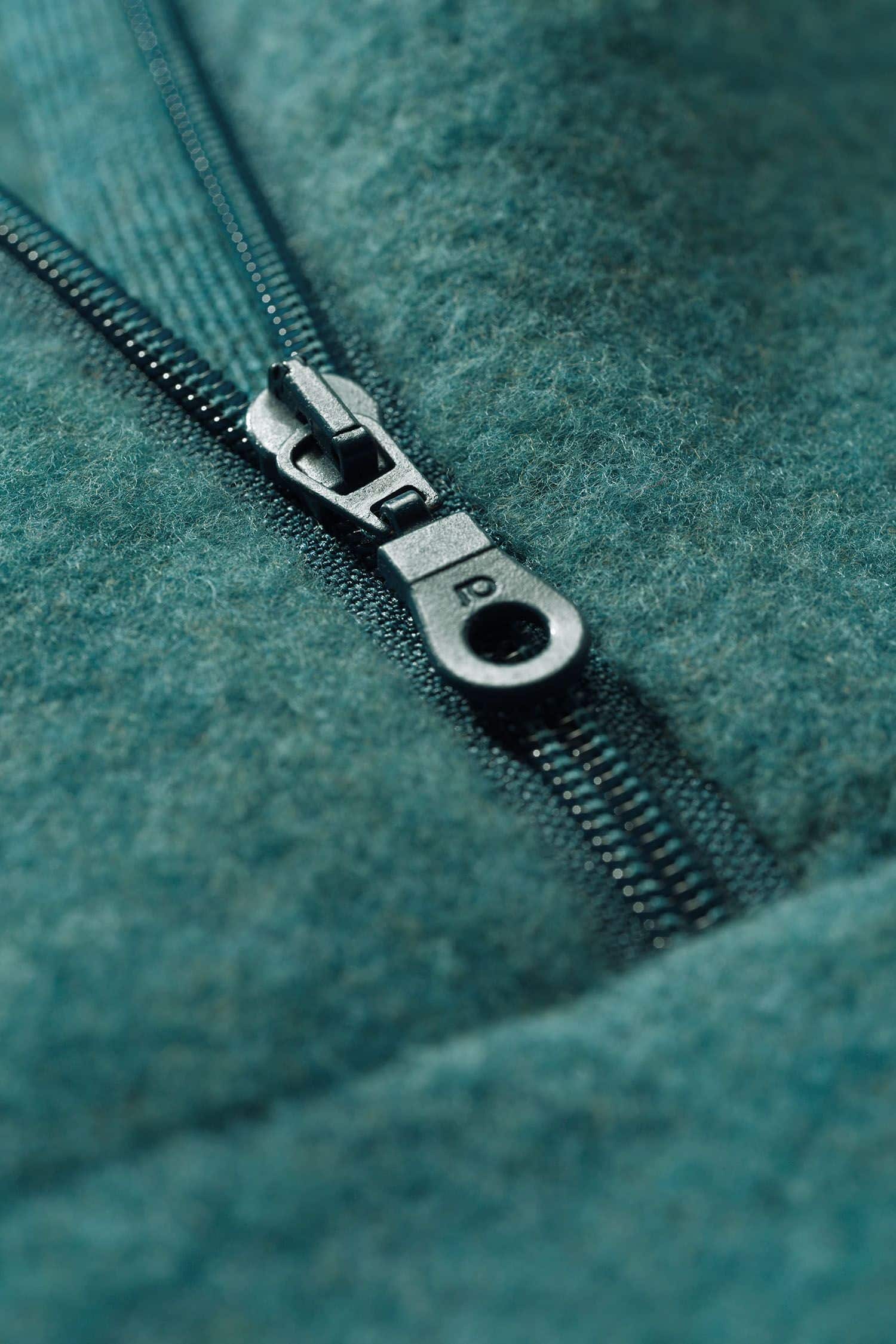 Detailaufnahme vom Reißverschluss des türkisen Wollfleecepullis mit hohem Kragen aus bio Wolle (kbT) vom Finkhof
