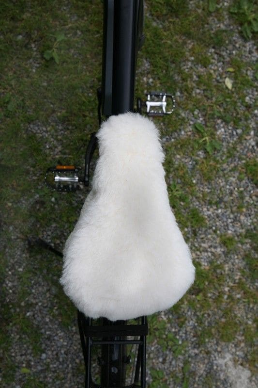schmaler weißer pflanzlich gegerbter Sattelbezug vom Finkhof aus bio Wolle (kbT) und Schaffell auf Fahrrad von oben