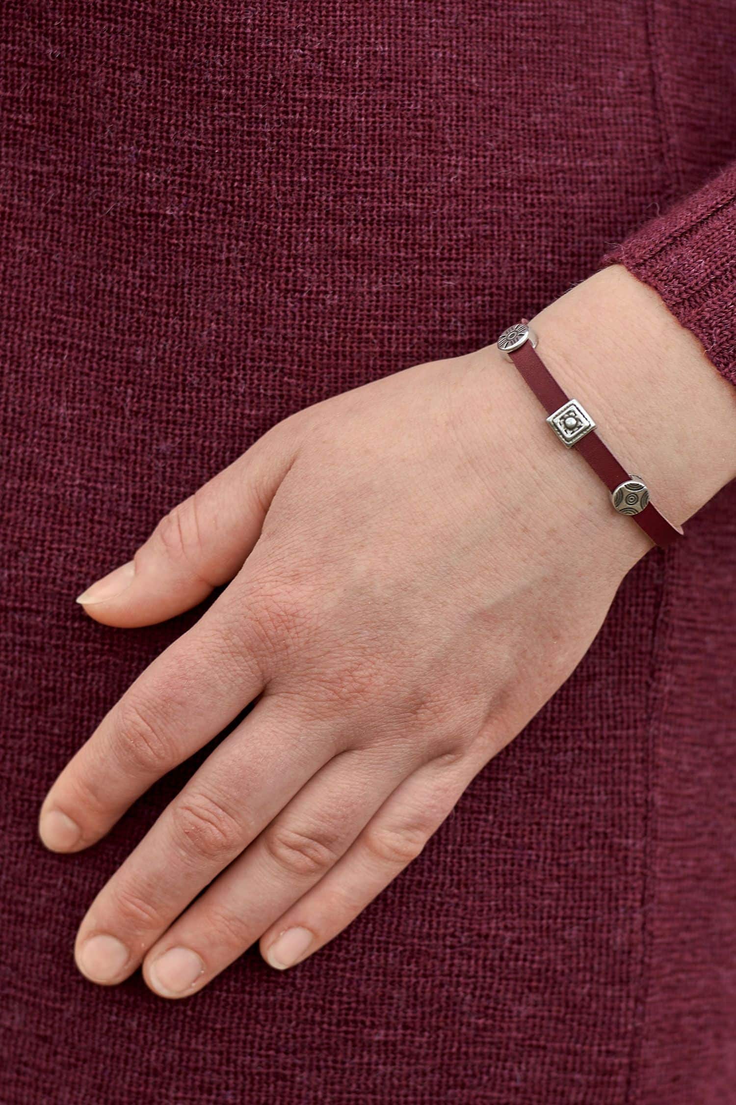 rotes Lederarmband mit silbernen Details aus pflanzlich gegerbtem Rindsleder mir weinrotem Pullover