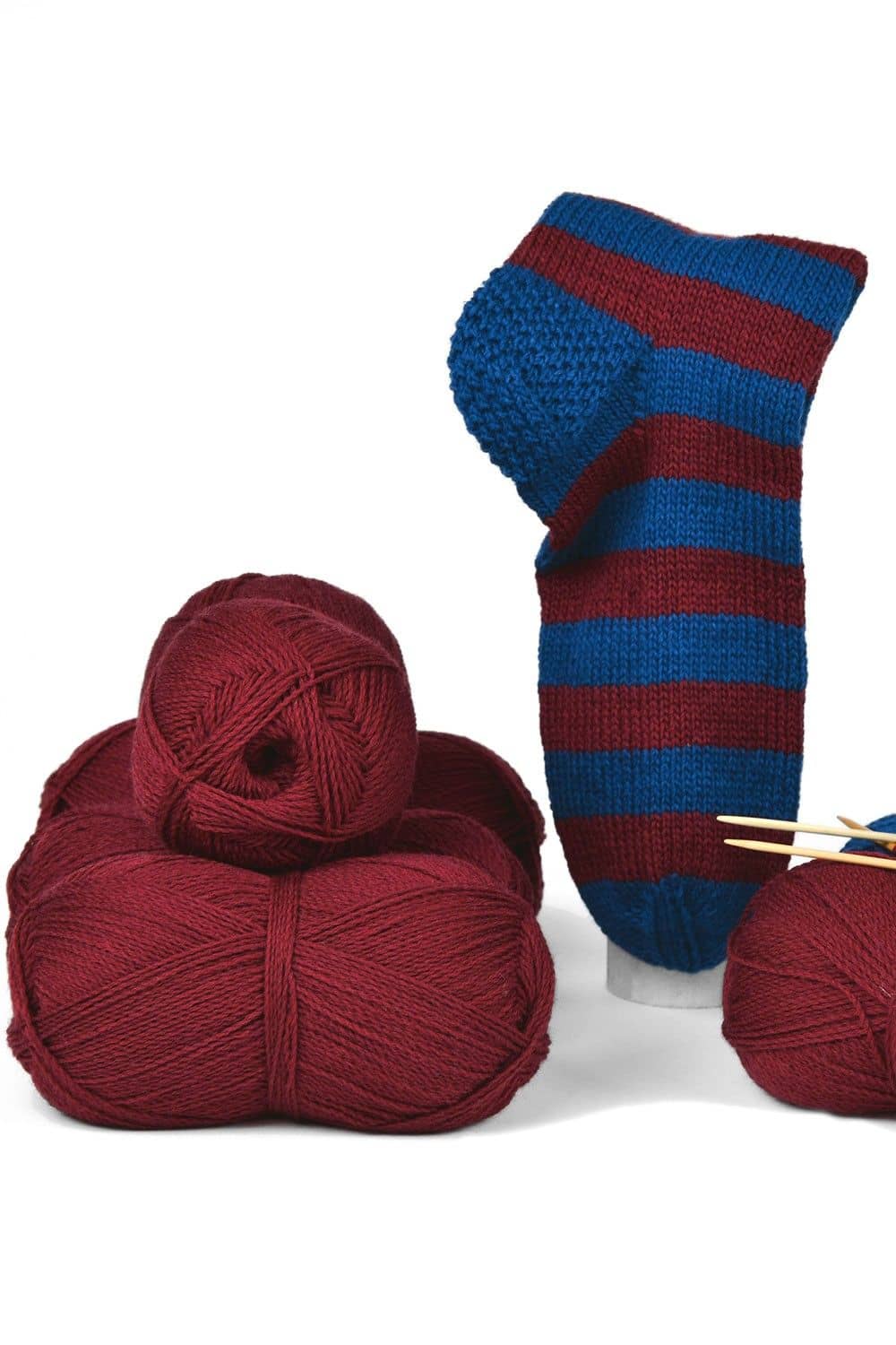 feine dunkelrote Finkhof Sockenwolle aus bio Wolle (kbT) als Knäule und fertiger blau rot gestreifter Socke