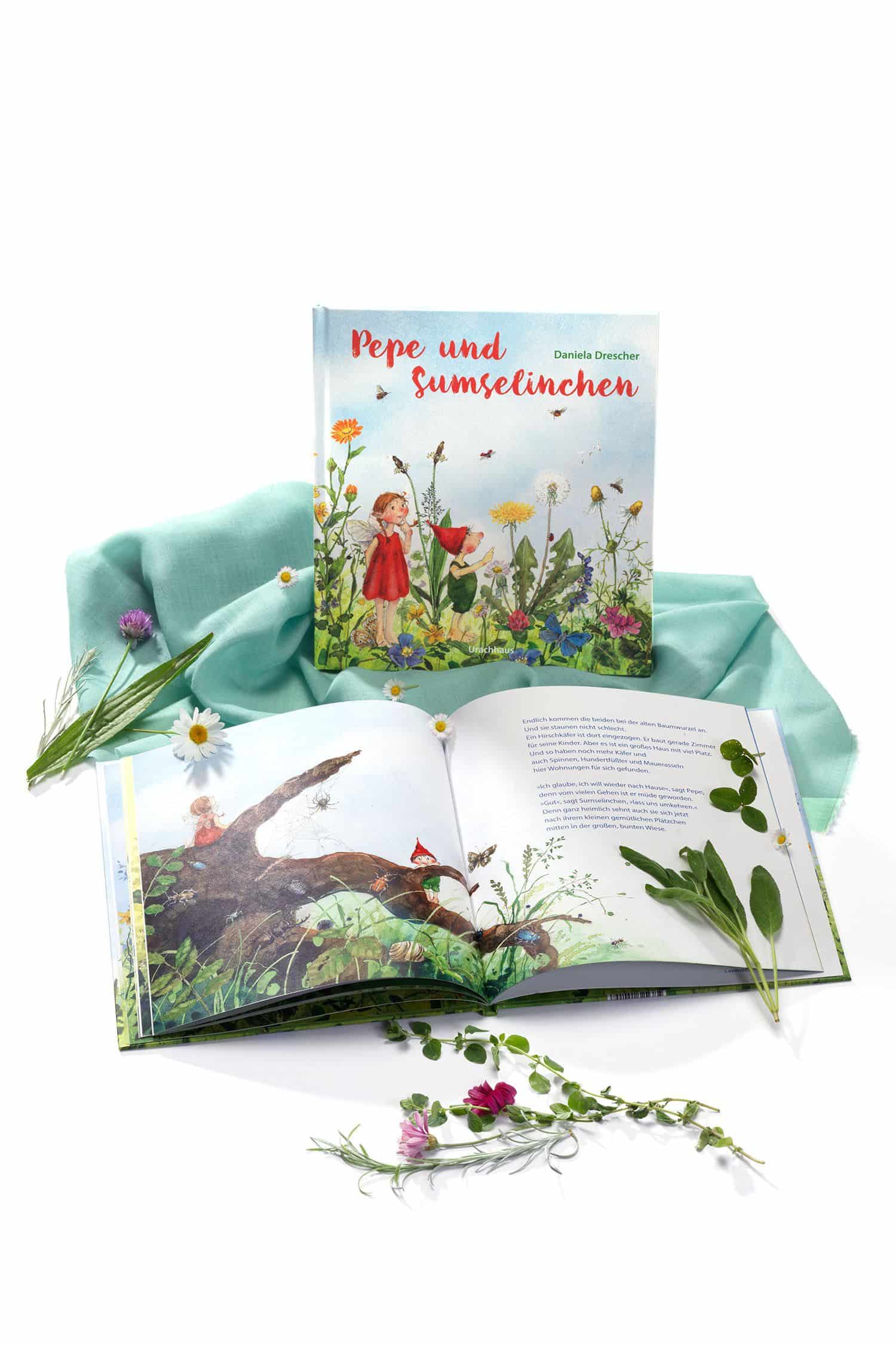 Pepe und Sumselinchen Buch ,,Pepe und Sunselinchen" mit aufgeschlagenem Exemplar und Blumen
