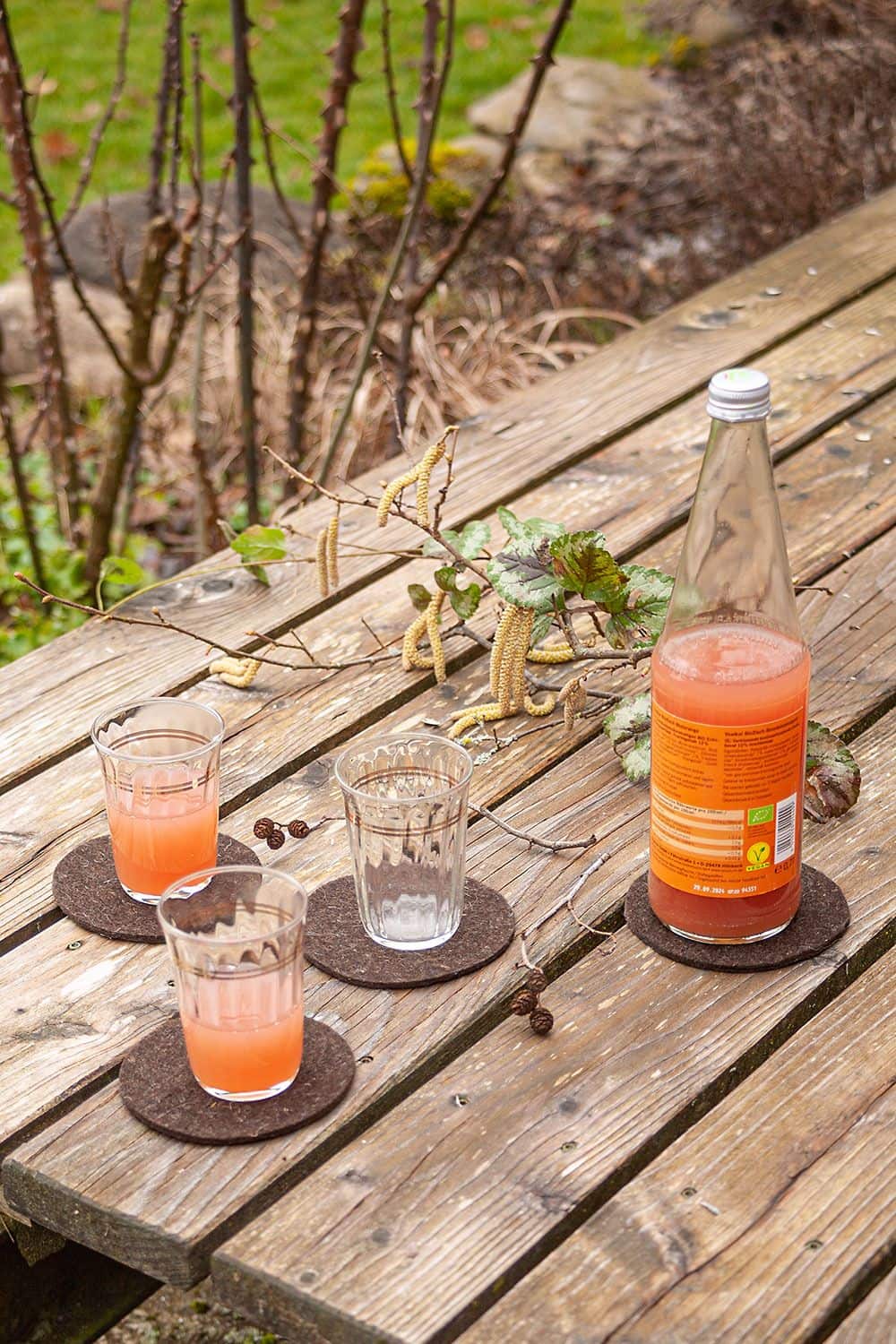 Getränkeuntersetzer als Anwendungsbeispiel für braunen Finkhof Wollfilz aus bio Wolle (kbT) mit Gläsern und Saft