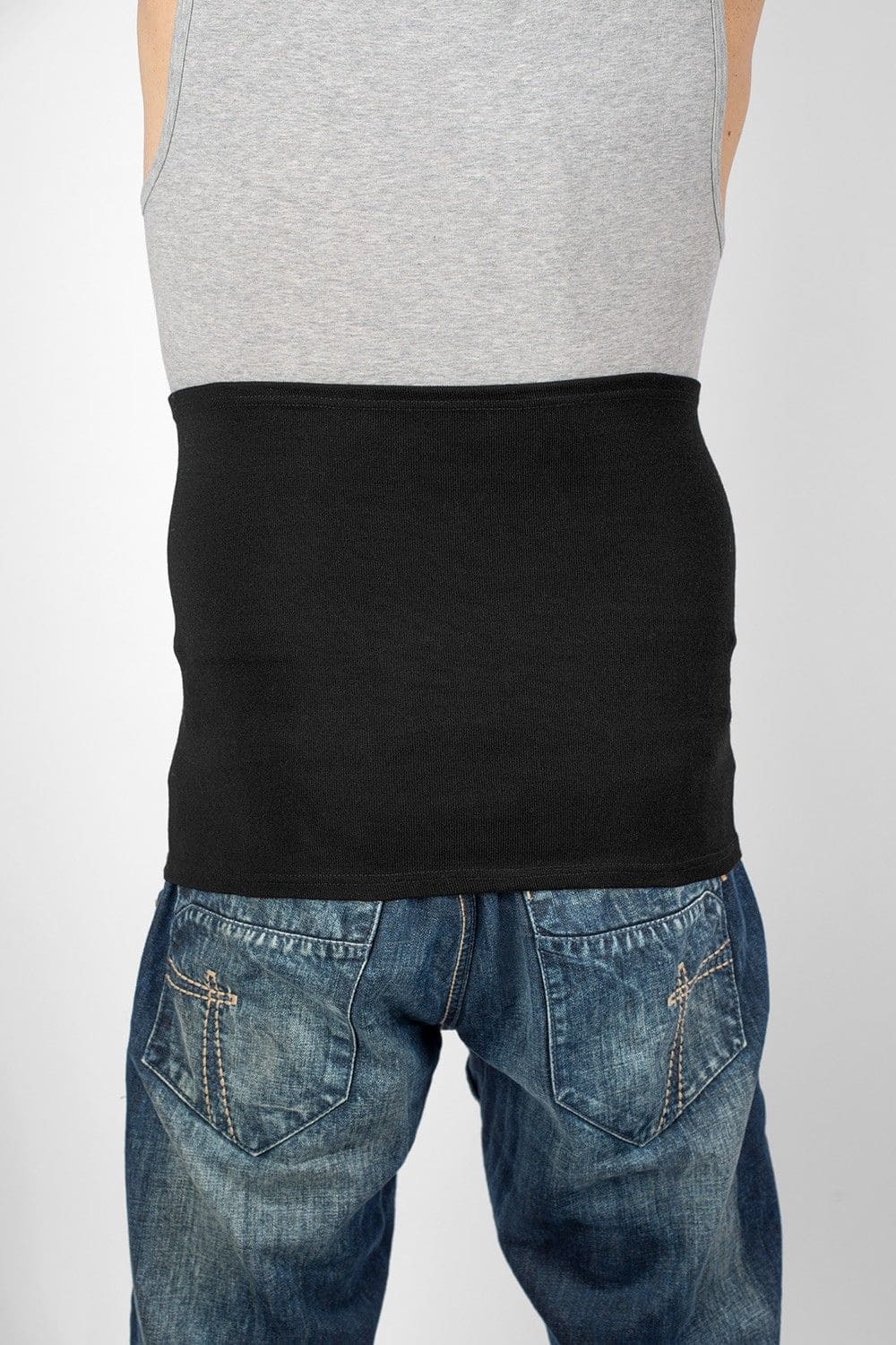 Model von hinten mit Jeans,Top und leichten schwarzen Nierenwärmer aus bio Wolle (kbT), Seide, Baumwolle und Elasthan