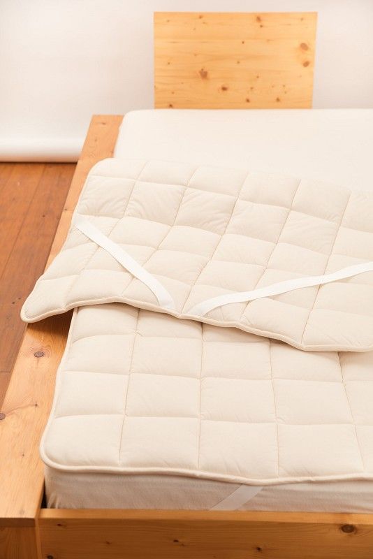 Wollunterbett dick dickes Wollunterbett vom Finkhof aus bio Wolle (kbT) und bio Baumwolle (kbA) auf braunem Holzbett