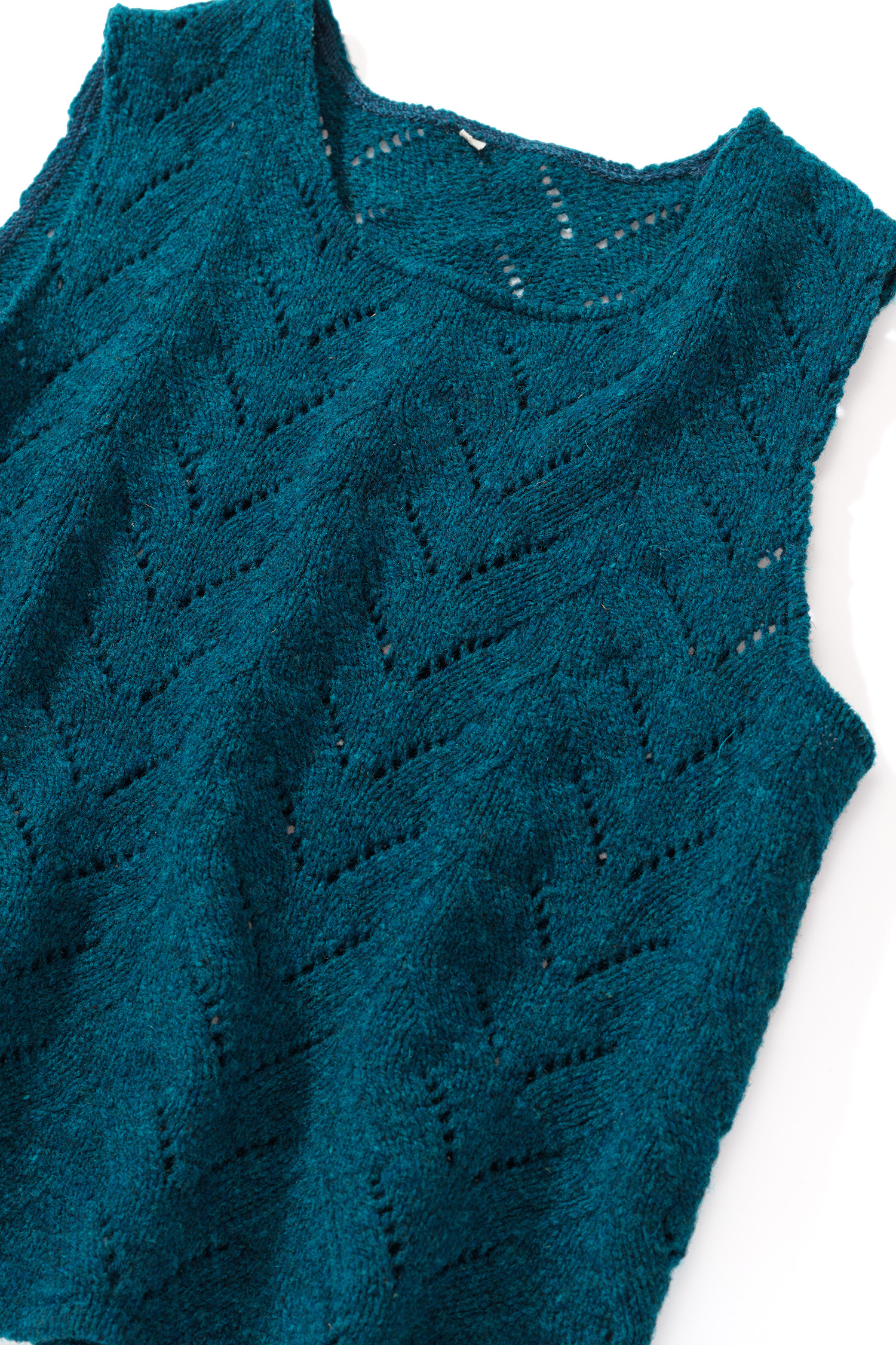 Nahaufnahme der Struktur des seeblauen Strickpullunder mit Ajourmuster vom Finkhof