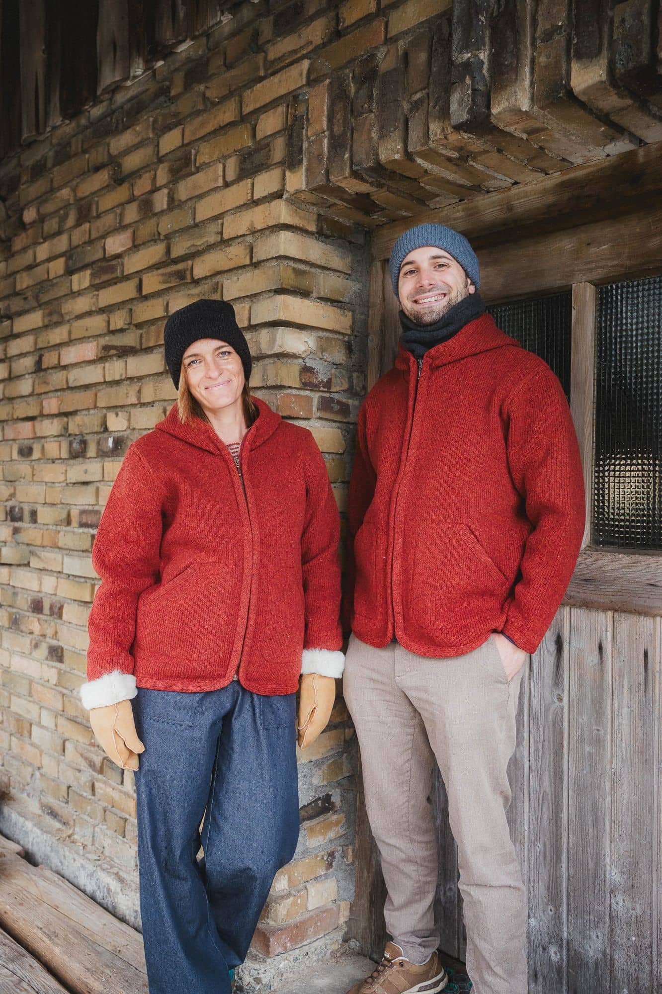 Mann und Frau tragen Mützen und rote Wollwalkjacken aus bio Wolle (kbT) vom Finkhof