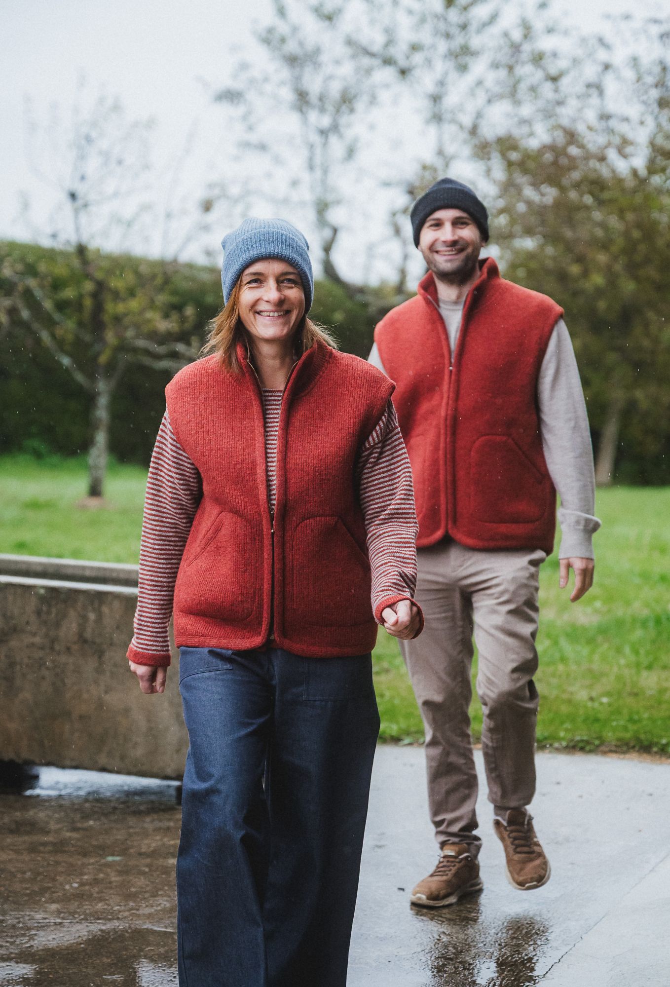 Mann und Frau tragen Mützen und rote Wollwalkwesten ohne Ärmel aus bio Wolle (kbT) vom Finkhof