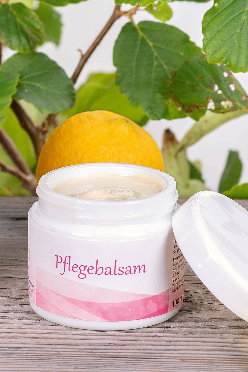 Pflegebalsam 100 ml - Sonderangebot MHD bald erreicht Finkhof Pflegebalsam in 100ml Tiegel auf Stimmungsbild mit Blättern, Orangen und Glastiegeln