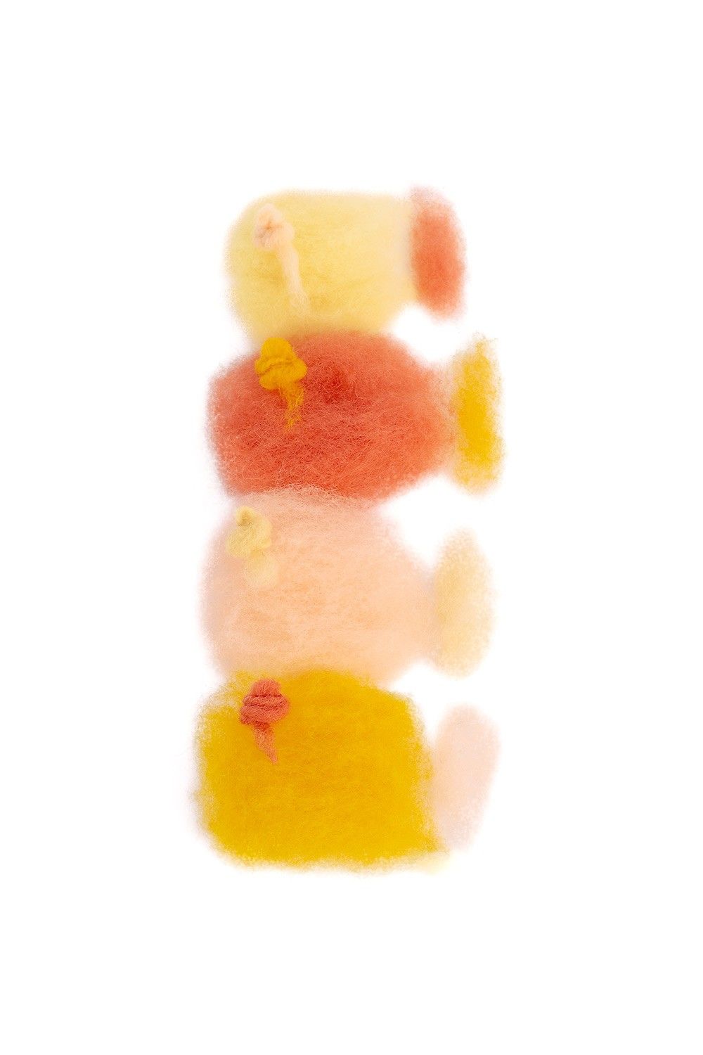 lose orange/gelbe Filzwolle auf weißem Untergrund aus der Finkhof Märchenwollepackung aus bio Wolle (kbT)