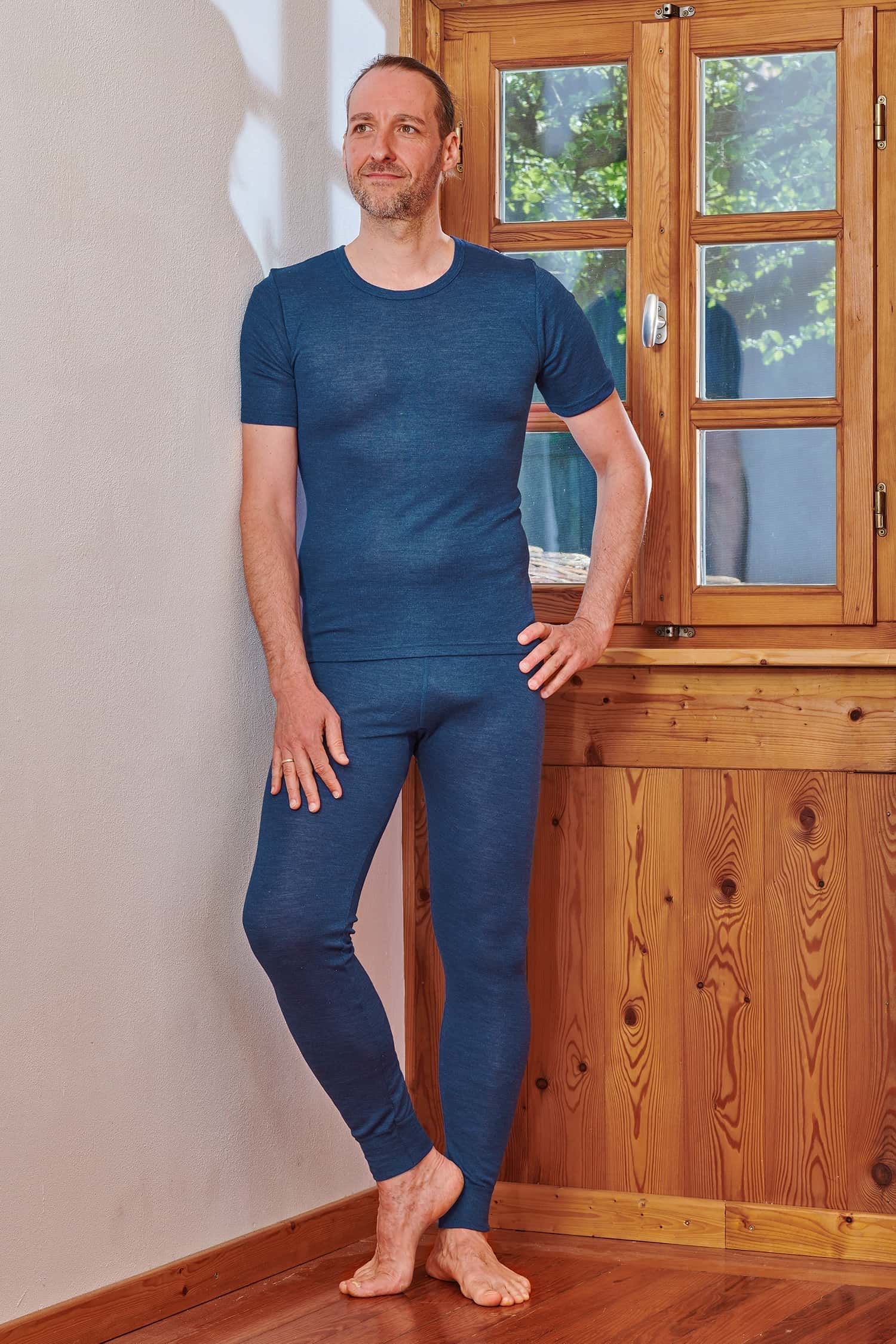 Mann trägt blaue lange Unterhose aus Bio-Wolle und Seide mit passendem Kurzarmshirt